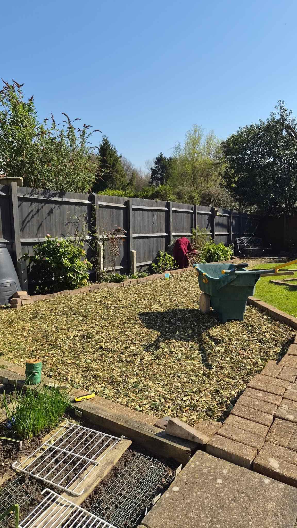 Freshly mulched garden bed ready for planting along a fence
